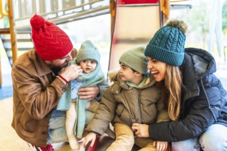 Cheerful parents are enjoying wintertime with their children at an indoor playground, creating a