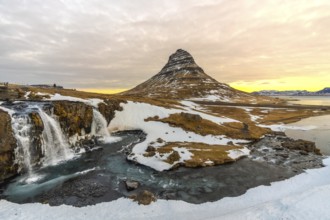 Wonderful sunrise landscapes on famous Kirkjufell mountain next to waterfall in winter Iceland