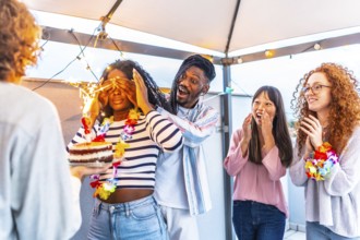 Multiracial young group of friends at terrace covering the eyes of a woman to surprise her with