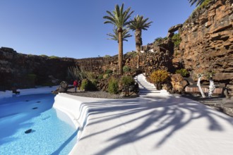 Palm trees, people walking by the swimming pool, Jameos del Agua, Lanzarote, Spain, Europe