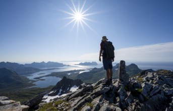 View of mountains and fjord landscape, mountaineer at the summit of Rundfjellet, Sun Star,