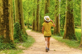 A woman with a hat walking through a forest in the Monasterio de Piedra Natural Park, Aragon