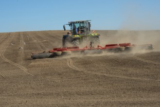 Tractor with rollers preparing the ground for spring sowing at Krageholm, Ystad Municipality, Skåne