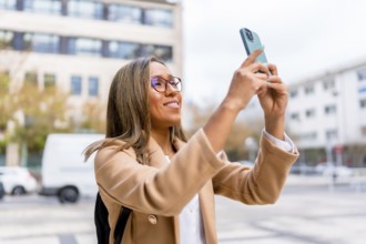 Latin female traveler taking photos of a city while walking along the street