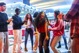 Cheerful multi ethnic friends dancing joyfully and enjoying their time together at the lively