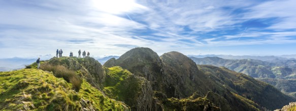Group of hikers enjoying stunning views from the peak of aiako harria mountain in oiartzun,
