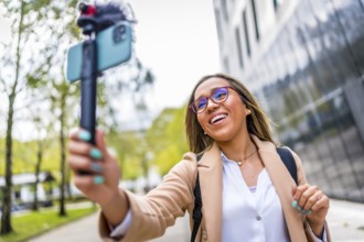 Latin woman vlogger talking to the camera while recording video blog in the city