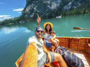 Family taking a selfie while enjoying a boat trip on the beautiful lake braies, surrounded by the