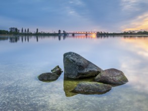 Sunrise at the historic lift bridge of Lindaunis over the Schlei, boulders in the water, Holstein