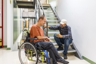 Man with disability talking with colleague in a coworking coffee break into a modern building
