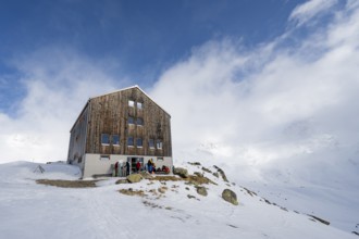 Chamanna Es-cha mountain hut in a cloudy winter mountain landscape, Bündner Haute Route ski tour,