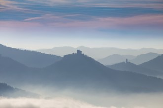 Autumnal panorama of the Palatinate Forest with mountain peaks and valleys in the mist. Trifels