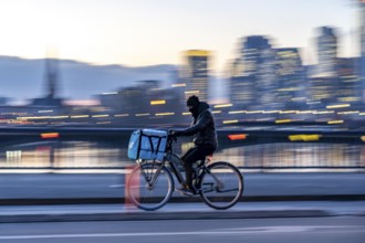 Skyline of the city centre of Frankfurt am Main, cyclist on the Flößerbrücke, Wolt delivery