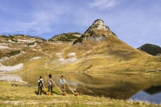 Three men play the alphorn at Lake Augstsee on Mount Loser. The Austrian alphorn trio Klangholz.