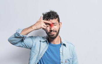 Young man with pain touching nose. A person with nasal bridge pain, Man with nasal bridge headache.