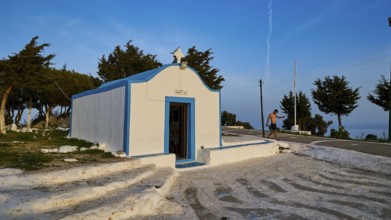 Profitis Ilias Chapel, White and blue chapel in Greece, surrounded by trees on a sunny day, Anthony