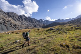 Mountaineers on a hiking trail, green high valley in atmospheric light, Keldike Valley on the way