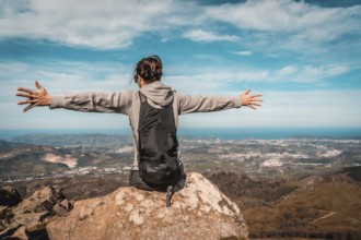 A young woman with open arms on top of Mount Adarra in Gipuzkoa. Basque Country