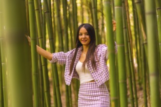 Young caucasian girl with a pink skirt in a bamboo forest. Enjoying the city on summer vacation in