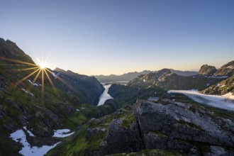 Picturesque mountain landscape at sunrise with sun star, fjord Trollfjord and Raftsund, hike to