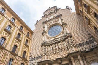 Low angle view of the montserrat monastery facade, featuring sculptures of biblical figures and a