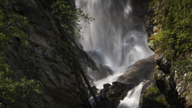A rushing waterfall flows over rocks in a wooded setting, Roståa stream, near Sel, Gudbrandsdalen,