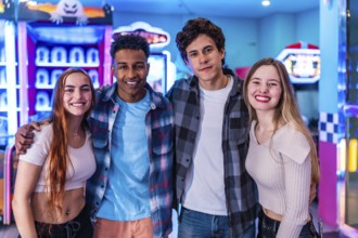 Four young multiethnic friends embrace, enjoying their weekend together at a vibrant bowling alley