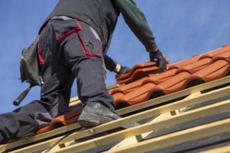 Roofer covering a tiled roof