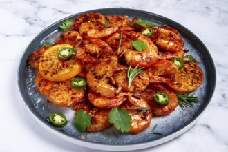 Grilled shrimp, unpeeled, headless, with spices, on a marble table, homemade, no people