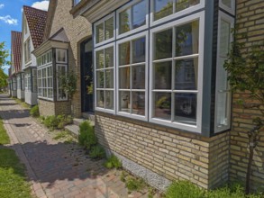 Historic row of houses with bay windows in Lange Strasse, gabled houses, footpath, trees, Arnis,