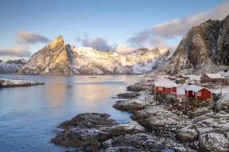 Rorbuer fishing huts in front of snow-covered mountains in winter, Hamnøy, Moskenesøy, Lofoten,