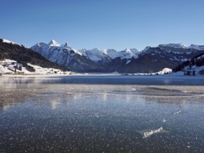 Frozen Sihlsee, reservoir, behind the snow-covered mountains Flübrig and Druesberg, Euthal, Canton