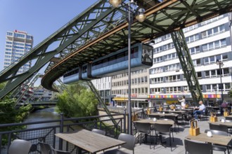 Train of the Wuppertal suspension railway runs along the Wupper, at the main station stop, terrace