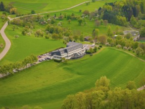 Hotel Large building on green meadows with surrounding trees and roads in the landscape, Glems