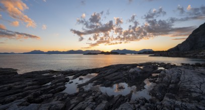Clouds reflected in a small pond on a rocky coast, coastal landscape at sunset, Henningsvær,
