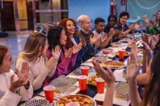 Young diverse people celebrating and having fun together at a bowling alley restaurant, enjoying