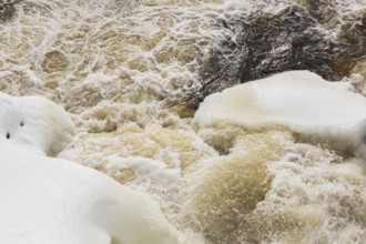 Packed snow with ice and strong water current released through water flow control gates on