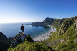 Mountaineer with view of coastal landscape, cliffs with summit Måtind or Måtinden, Høyvika beach