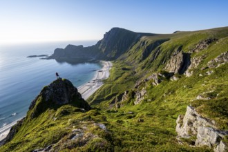 Climber on a rock, view of picturesque coastal landscape, steep coast with peak Måtind or Måtinden,