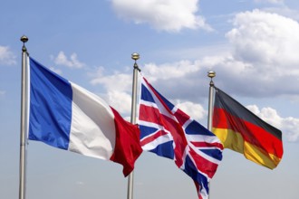 (Photomontage) Flags of France, Great Britain and Germany against a blue sky