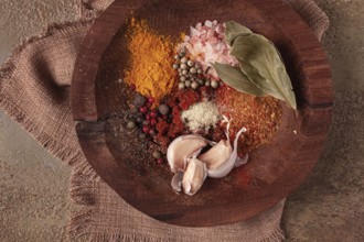 Spice mix, garlic and bay leaf, on a wooden plate, close-up, food concept, no people