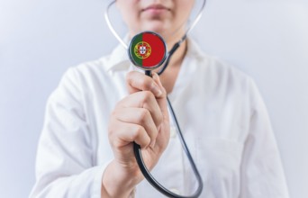 Female doctor holding stethoscope with Portugal flag. National health system of Portugal