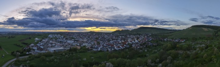 Urban panorama at dusk with dense clouds and rolling hills in the distance, Korb-Steinreinach, Rems