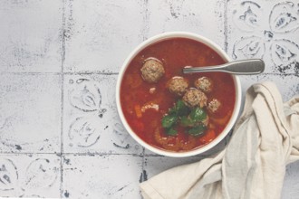 Romanian soup with meatballs, vegetable soup with meatballs, tiled table, homemade, no people