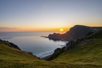 View of coastal landscape at sunset, cliffs and summit of Måtind or Måtinden, Høyvika beach and