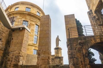 Roman statue standing tall amidst the ruins of tarragona, showcasing the city's rich historical