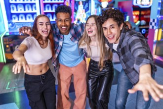 Four young multiethnic friends are enjoying their weekend together at an arcade, playing games and