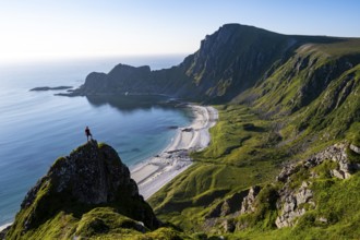 Climber on a rock, view of picturesque coastal landscape, steep coast with peak Måtind or Måtinden,