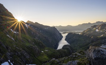 Picturesque mountain landscape at sunrise with sun star, fjord Trollfjord and Raftsund, hike to