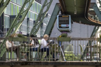 Train of the Wuppertal suspension railway runs along the Wupper, at the main station stop, terrace